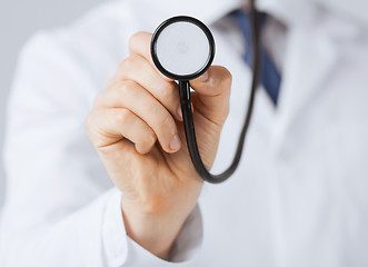 Image showing doctor hand with stethoscope listening something