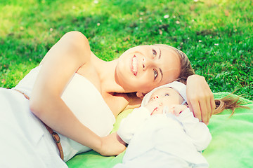 Image showing happy mother lying with little baby on blanket