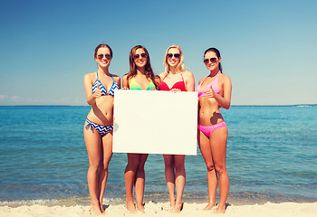 Image showing group of smiling women with blank board on beach