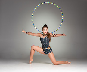 Image showing teenager doing gymnastics exercises with colorful hoop