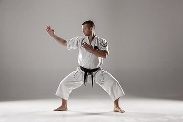 Image showing Man in white kimono training karate