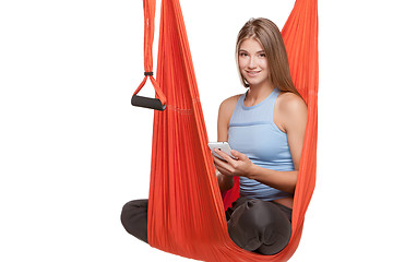 Image showing Young woman sitting in hammock for anti-gravity aerial yoga