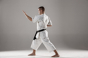 Image showing Man in white kimono training karate