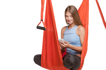 Image showing Young woman sitting in hammock for anti-gravity aerial yoga