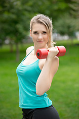 Image showing Sports girl exercise with dumbbells in the park