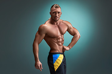 Image showing Attractive male body builder on blue background