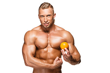 Image showing Shaped and healthy body man holding a fresh orange fruit,  isolated on white background