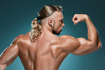 Image showing Attractive male body builder on blue background