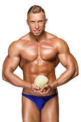 Image showing Shaped and healthy body man holding a fresh cabbage ,  isolated on white background