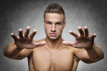 Image showing Athlete holds up his hands