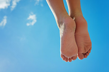 Image showing Children\'s feet with sand against the blue sky