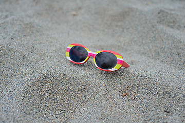 Image showing Children\'s striped sunglasses on the sand