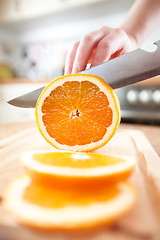 Image showing Woman\'s hands cutting orange