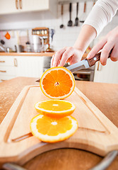 Image showing Woman\'s hands cutting orange