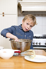 Image showing Young boy baking pies in a kitchen