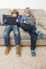 Image showing Two boys playing video games on a tablet computer