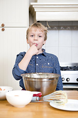 Image showing Licking batter from a bowl in a kitchen