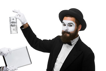 Image showing businessman\'s hand in the form of mime extract money from tablet PC