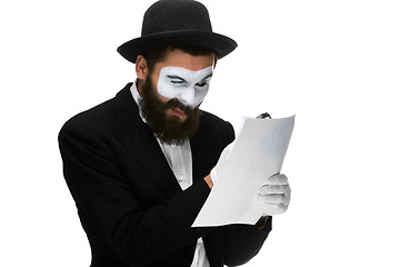 Image showing Man with a face mime reading through magnifying glass 