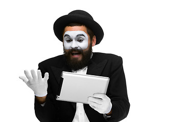 Image showing Man with a face mime working on  laptop 