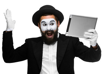 Image showing Man with a face mime working on  laptop 