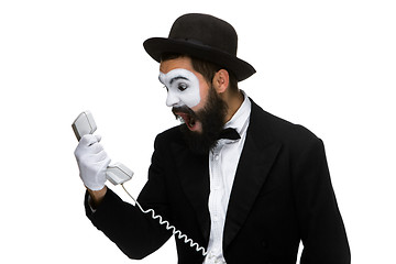 Image showing angry and irritated  man screams into the telephone receiver 
