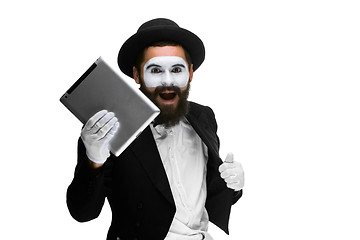 Image showing Man with  face mime working a laptop isolated on  white background.