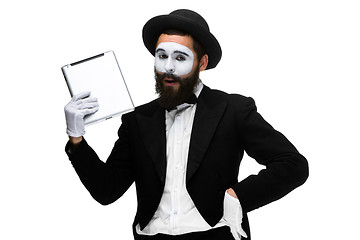 Image showing Man with a face mime working on a laptop isolated on a white background. 