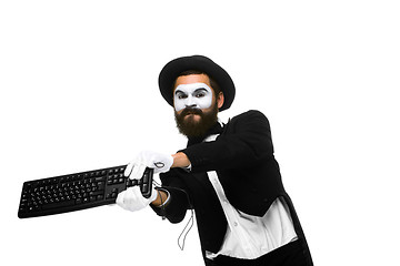 Image showing Angry mime as a businessman is destroying  keyboard