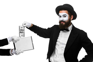 Image showing businessman\'s hand in the form of mime extract money from tablet PC