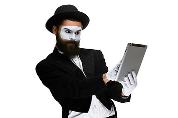 Image showing Man with a face mime working on  laptop 