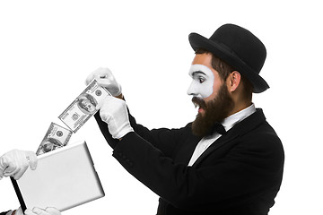 Image showing businessman\'s hand in the form of mime extract money from tablet PC