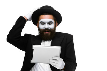 Image showing Man with a face mime working on laptop 