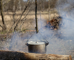 Image showing Cooking in sooty cauldron on campfire