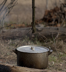 Image showing Cooking in old sooty cauldron on campfire