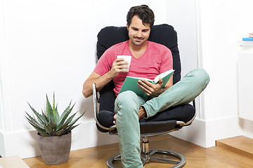 Image showing Man Sitting on Chair with Book and a Drink