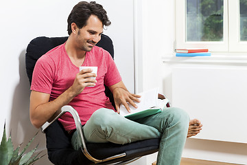 Image showing Man Sitting on Chair with Book and a Drink