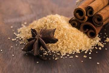 Image showing Cinnamon sticks with pure cane brown sugar on wood background