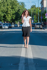 Image showing Pretty businesswoman walking on road