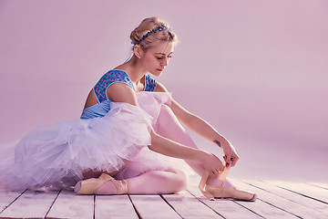 Image showing Professional ballerina putting on her ballet shoes.