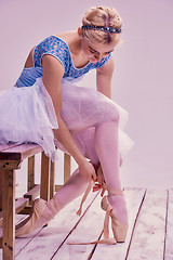 Image showing Professional ballerina putting on her ballet shoes.