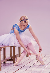 Image showing Professional ballerina putting on her ballet shoes.