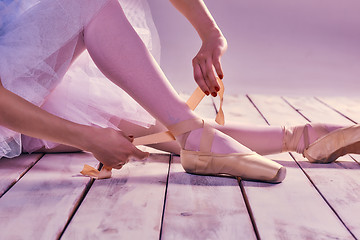 Image showing Professional ballerina putting on her ballet shoes.