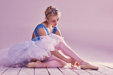 Image showing Professional ballerina putting on her ballet shoes.