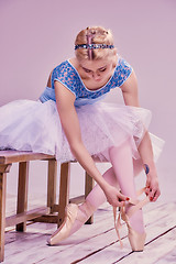 Image showing Professional ballerina putting on her ballet shoes.