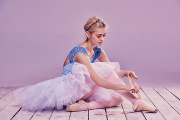 Image showing Professional ballerina putting on her ballet shoes.