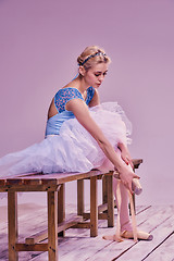 Image showing Professional ballerina putting on her ballet shoes.