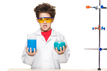 Image showing Little boy as chemist doing experiment with chemical fluid in the laboratory