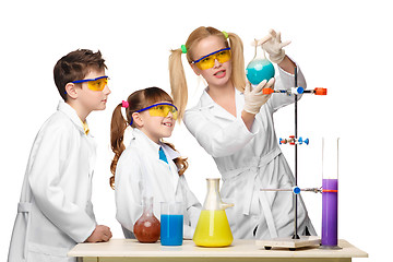 Image showing Teens and teacher of chemistry at  lesson making experiments