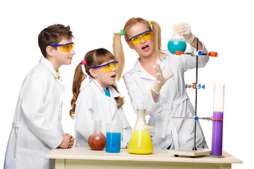 Image showing Teens and teacher of chemistry at  lesson making experiments